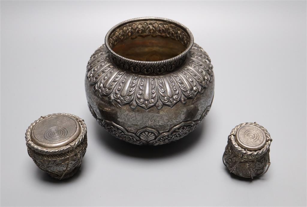 An Indonesian? embossed and engraved white metal squat vase, height 12.2cm and two similar lidded pots,